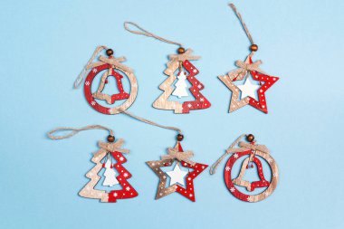 Mavi arka plan üzerinde ahşap Noel süsleri kümesi. Üstten görünüm, düz yatıyordu.