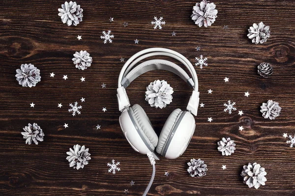 Białe Słuchawki Śniegu Malowane Szyszki Drewnianym Stole Koncepcja Muzyki Bożego — Zdjęcie stockowe