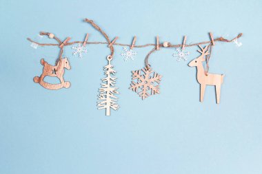 Ahşap dekorasyon clothespins kopya alanı ile mavi arka plan üzerinde dur. Sallanan at, köknar, kar taneleri ve geyik bileşimi. Üstten görünüm, düz yatıyordu. 