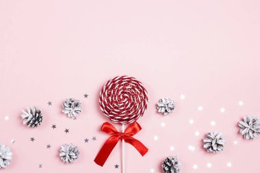 Dekoratif Noel lolipop ve koniler pembe bir arka plan üzerinde. Düz yatıyordu tepeden kompozisyon.