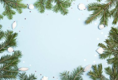 Beyaz baubles ve mavi bir arka plan üzerinde kopya alanı ile Noel köknar ağacı dalları. Noel yeşil çerçeve.