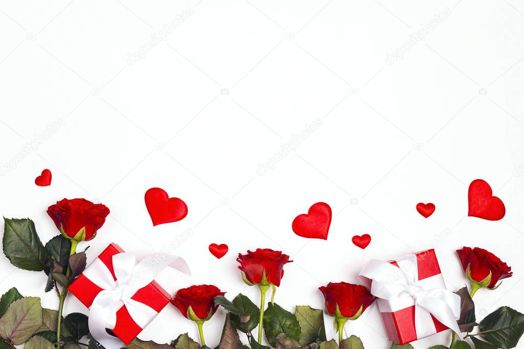 Border of gifts, rose flowers and decorative hearts on white background. Place for text, top down composition. St. Valentines Day concept.