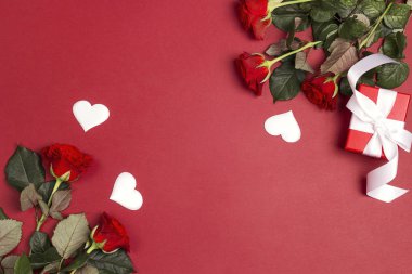 Gül çiçek, hediye kutusu ve kırmızı zemin üzerine dekoratif kalpler. Metin, kompozisyon en iyi yer. St Sevgililer günü kavramı. 