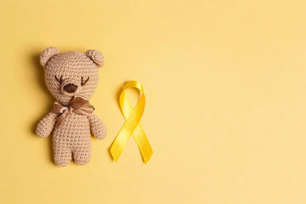 Barnleksak Med Barndom Cancer Awareness Yellow Ribbon Gul Bakgrund Barndomen — Stockfoto