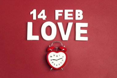 St Sevgililer günü tarihi, kelime aşk ve kırmızıya çalar saat ile arka plan. Yukarıdan aşağıya kompozisyon.
