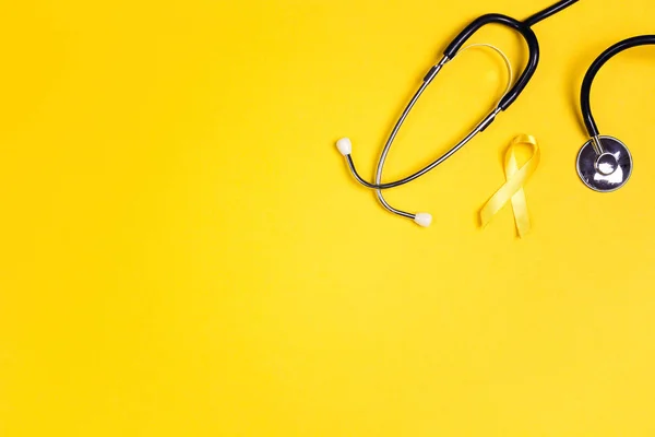 Childhood Cancer Awareness Yellow Ribbon and stethoscope on yell