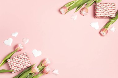 Lale, hediyeler ve pastel pembe kalpler ile romantik çerçeve çiçek arka plan. Uzay kopyalayın, yatıyordu, en iyi görünüm düz. 