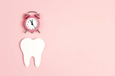 Beyaz diş çalar saat üzerinde pembe bir arka plan ile. Zaman diş için 