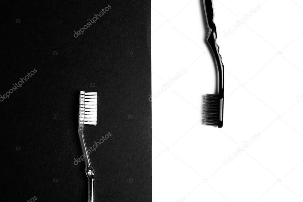 Black and white toothbrushes on a black and white background.