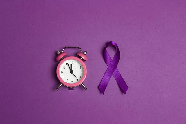 Фиолетовая лента эпилепсии с будильником на фиолетовой палочке — стоковое фото