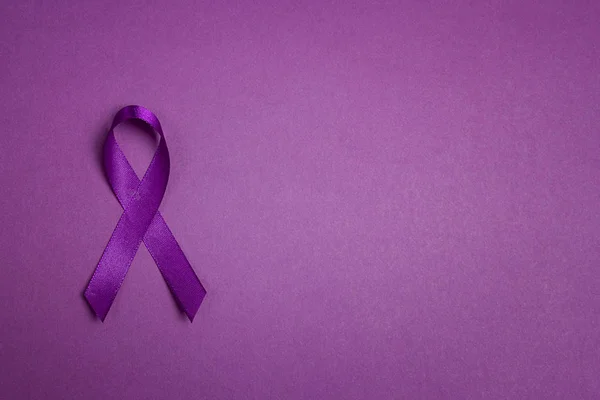 Purple epilepsy awareness ribbon on a purple background with cop