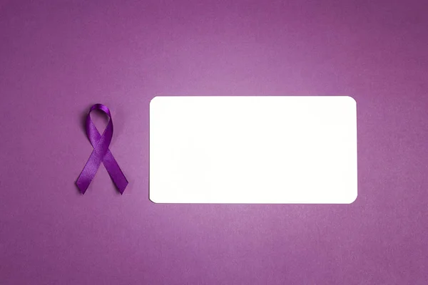 Purple epilepsy awareness ribbon with empty white card on a purp