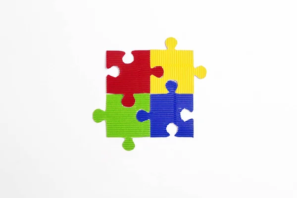 Vier farbige Puzzleteile auf weißem Hintergrund. Autismus-Preisträger — Stockfoto