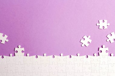 Mor bir arka plan üzerinde beyaz puzzle parçaları.