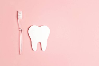 Beyaz kağıt diş diş fırçası üzerinde pembe bir arka plan ile. Diş hea