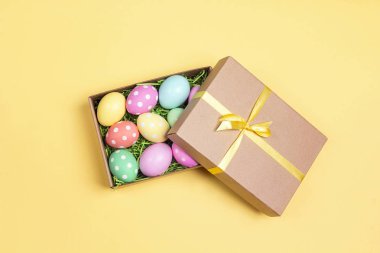 Paskalya yumurtaları sarı arka plan bir hediye kutusunda.