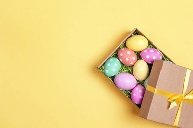 Paskalya yumurtaları bir hediye kutusunda Sarı zemin üzerine. Kopya alanı için t