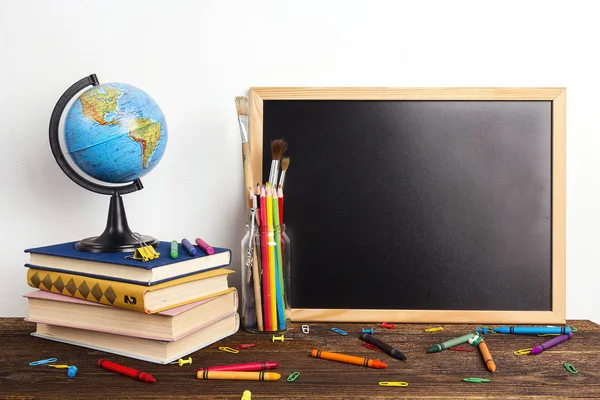 Education composition from a clean chalkboard, a globe, a stack