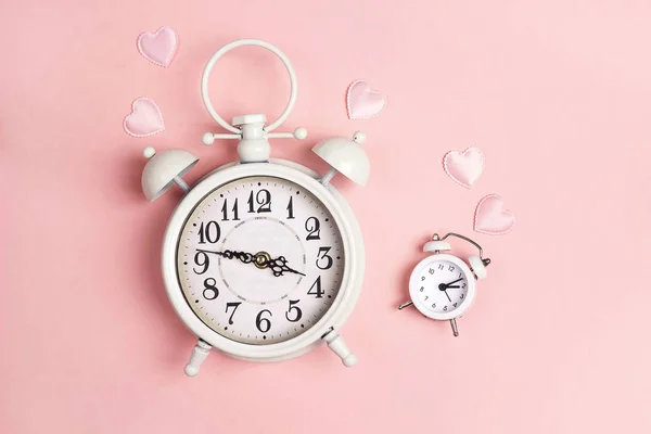 Relojes de alarma blancos grandes y pequeños como mamá e hija en rosa . — Foto de Stock