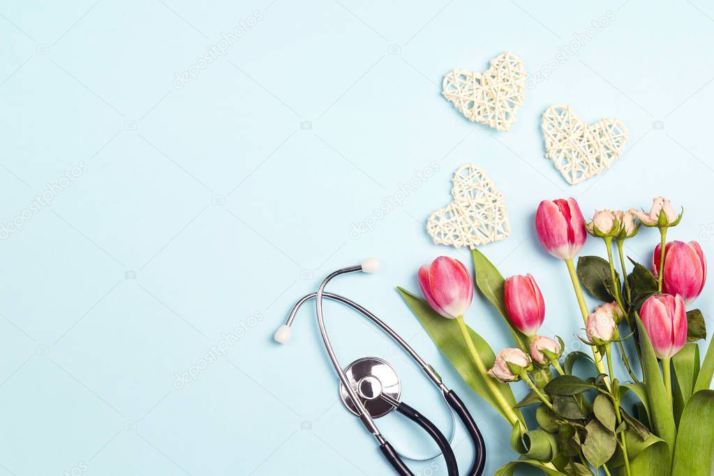 Bunch of tulips and roses with stethoscope on blue background. T