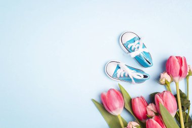 Mavi bir backgro üzerinde tulup çiçek ile Sevimli mavi erkek bebek spor ayakkabıları