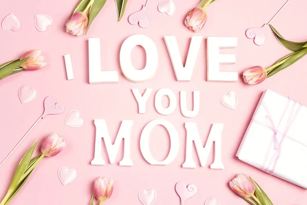 Message de la fête des mères avec tulipes et cœurs sur fond rose. F — Photo