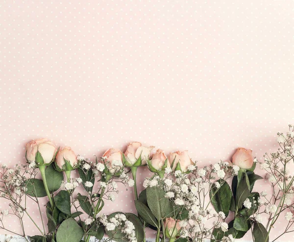 Frontera de pequeña rosa y gypsophila en un fondo de lunares rosa —  Fotos de Stock