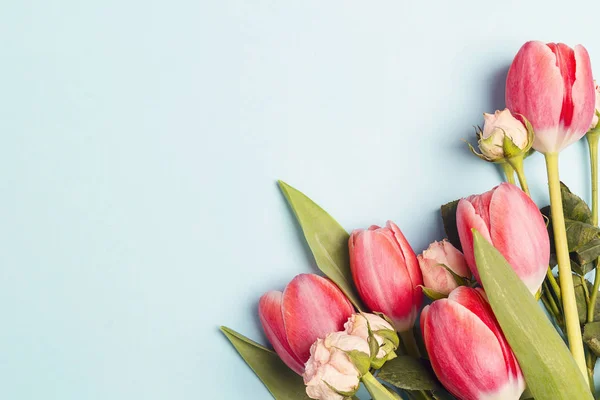 Buquê de tulipas e rosas em um fundo azul . — Fotografia de Stock