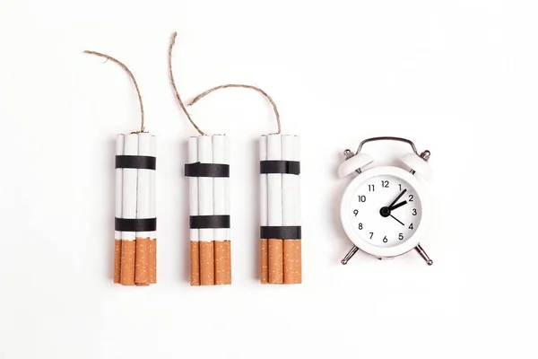 Dynamite made from cigarettes with alarm clock on white backgrou — Stock Photo, Image