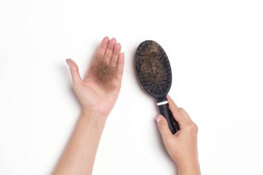 Düşmüş saçlı tarak ile kadın elleri. Saç dökülmesi sorunu.