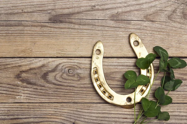 St.Patrick's Day. Golden horseshoes with clover leafs on wooden — Stock Photo, Image