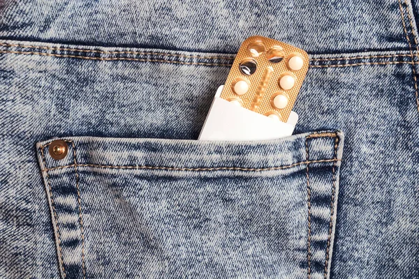 Pílulas contraceptivas orais femininas blister no bolso jeans . — Fotografia de Stock