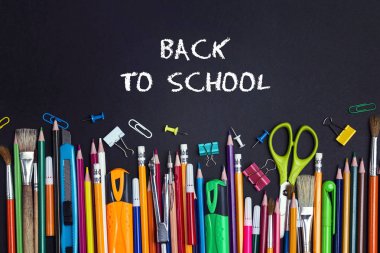 Siyah arka plan üzerinde okul malzemeleri ile okul kavramına geri dön.