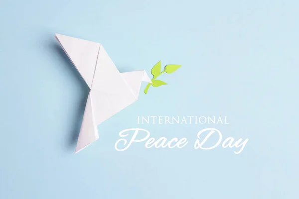 World Peace Day greeting card. Paper origami dove of peace with