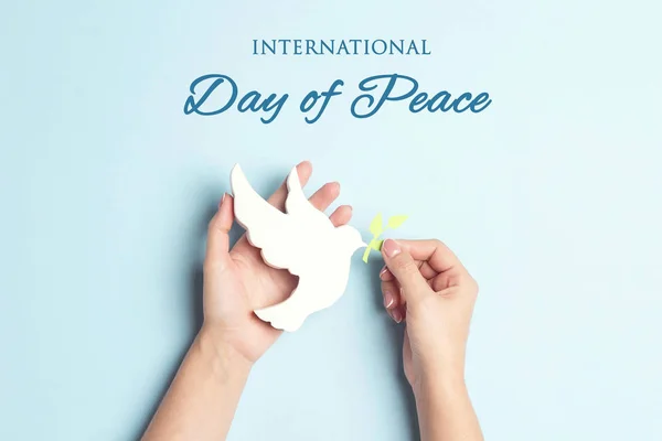 World Peace Day greeting card. Female hands hold dove of peace w