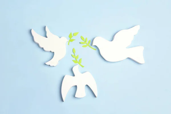 Three doves of  peace with olive branches on a blue background.