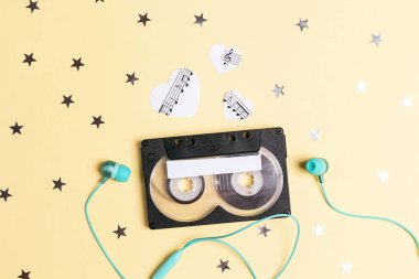 Sarı arka planda kulaklıklı klasik kaset kaseti.