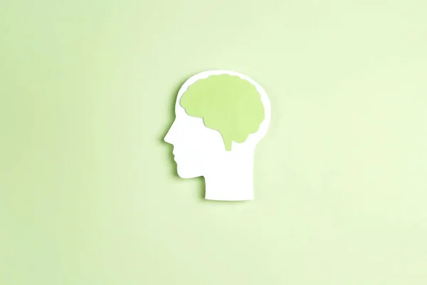 Силуэт головы человека с мозгом на зеленом фоне . — стоковое фото