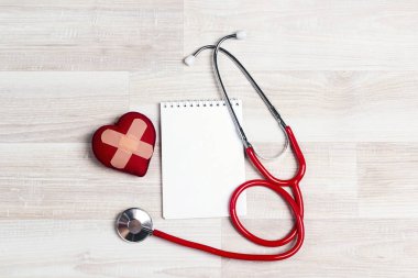 Masada steteskop ve kalp olan boş defter. Kopyalama alanı ile Dünya kalp günü kavramı.