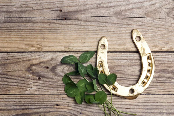 St.Patrick's Day. Golden horseshoes with clover leafs on wooden — Stock Photo, Image