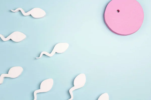 Spermie pohybující se k vajíčku na růžovém pozadí. — Stock fotografie