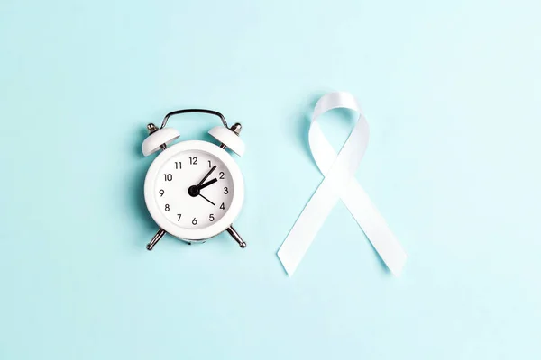 흰 폐암 인식 리본 과 파란 백 그 위의 알람 시계 — 스톡 사진