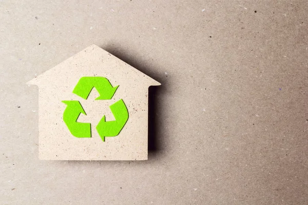 Ecologisch huis met recycling symbool op bruine papieren achtergrond — Stockfoto