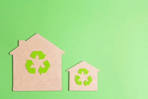 Ekologiska hus med återvinningssymbol på grön bakgrund. — Stockfoto