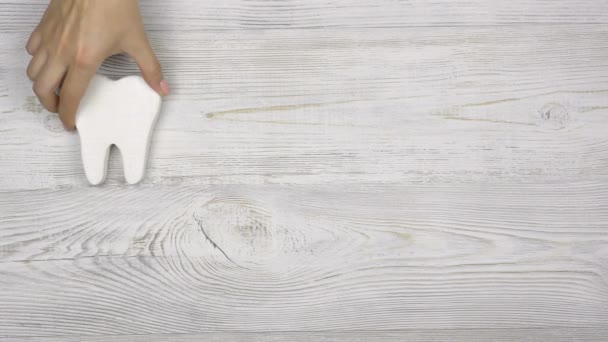 Vrouwelijke Hand Zet Tanden Een Roze Spaarvarken Bank Een Houten — Stockvideo