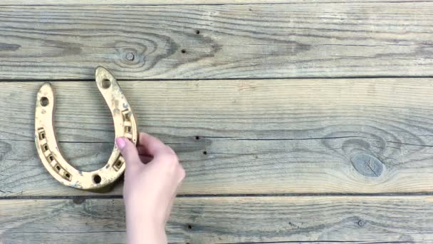 Mano Femenina Pone Una Herradura Dorada Hojas Trébol Viejas Tablas — Vídeo de stock