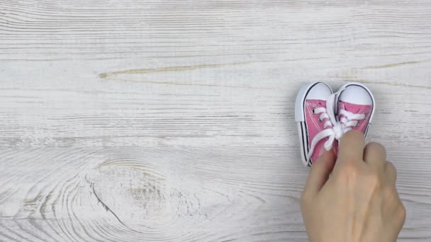 Main Féminine Met Bébé Rose Fille Bleu Bébé Garçon Baskets — Video