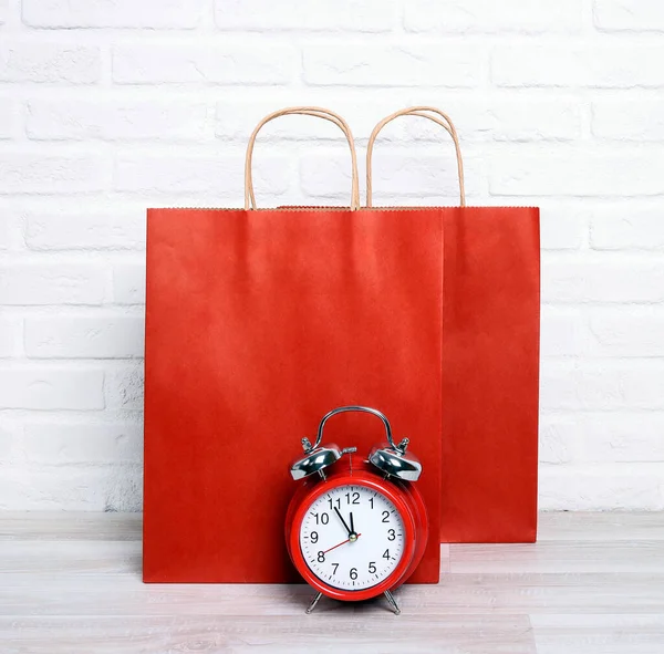 Bolsas Compras Papel Rojo Con Reloj Despertador Clásico Sobre Fondo —  Fotos de Stock