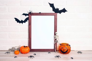 Beyaz tuğla duvara karşı cadılar bayramı süslemeleri olan boş ahşap çerçeve. Cadılar bayramı geçmişi. Tasarım için alanı kopyala.