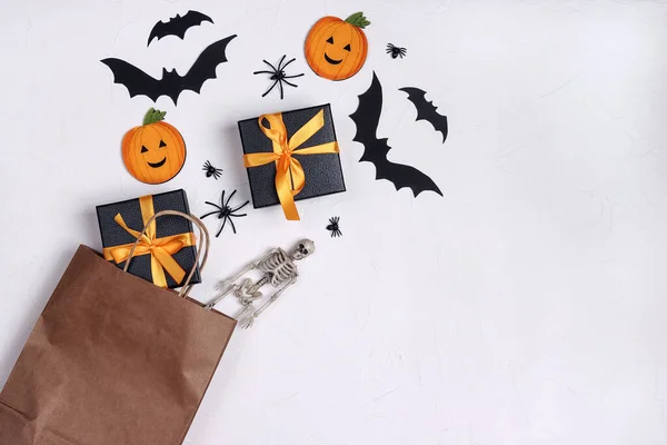 Brown paper shopping bag with Halloween decorations on white background. Copy space for text. Halloween shopping and sale concept.